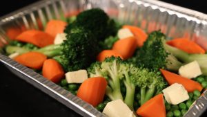 A tray of carrots, broccoli and peas.