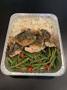 A container with chicken, green beans and rice.