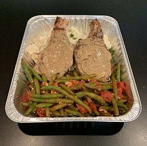 A tray with meat, green beans and mashed potatoes.